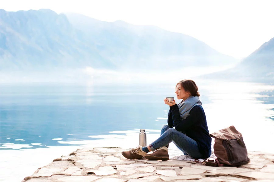 A woman sips coffee in beautiful surroundings, to show the efficacy of healing codependency at Exclusive Hawaii Rehab